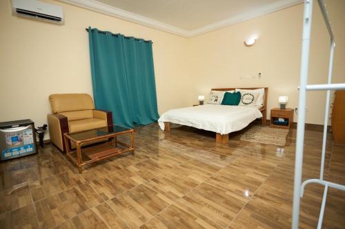 a bedroom with a bed and a chair at La Samurai House Assinie in Assinie
