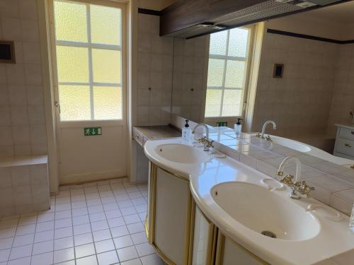 a bathroom with two sinks and a large mirror at Aspa Herrgård - Handelshuset in Askersund