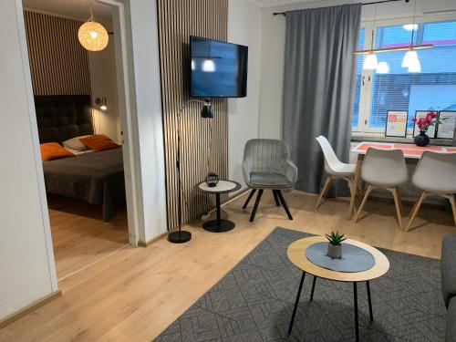 a living room with a couch and a table and chairs at StarHomes Oulu, double in Oulu