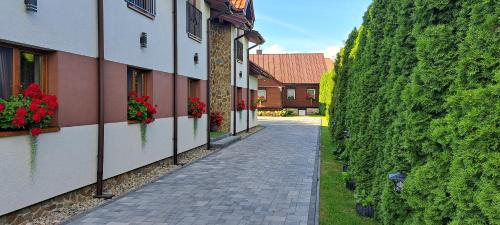 an alley in a building with flowers on the side at Pod Dachem Tykocin in Tykocin