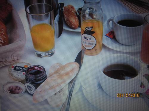 a breakfast table with a plate of bread and a cup of orange juice at Bed and Breakfast Paris Centre in Paris
