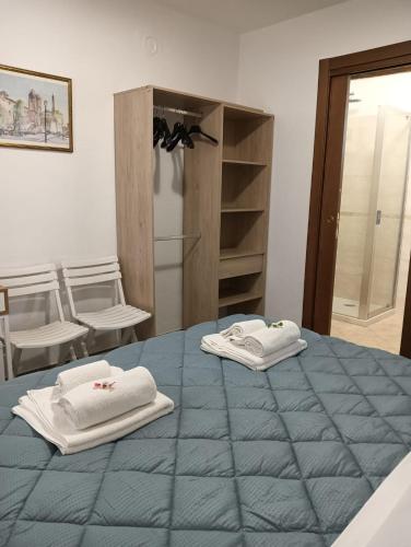 two towels sitting on top of a blue bed at La Casa del Postino in Farigliano