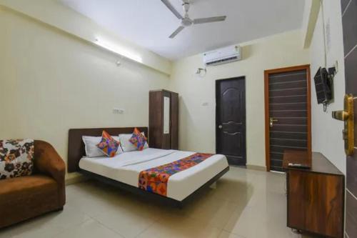 a bedroom with a bed and a couch in it at FabHotel Krishna Inn in Hinjewadi