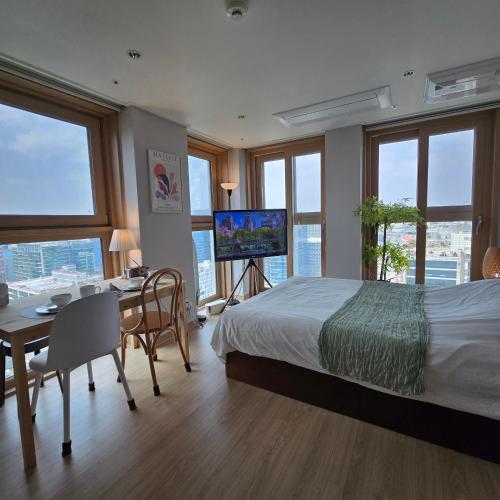 a bedroom with a bed and a desk and a television at 원스테이 가산디지털단지 in Seoul