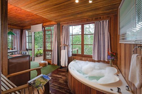 a large bathroom with a bath tub in a room at Casa da Colina Chalés in Visconde De Maua