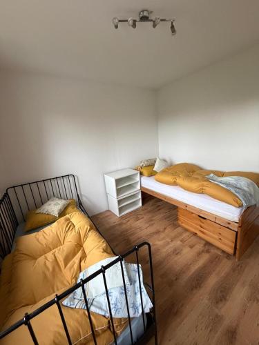 two twin beds in a room with wooden floors at Saarlouis2 in Saarlouis