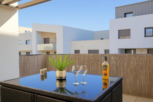 a table with two glasses and a bottle of wine at T3 moderne- Climatisé avec Parking & Terrasse à 5 min de Montpellier in Saint-Jean-de-Védas