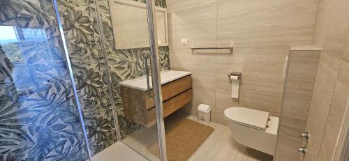 a bathroom with a toilet and a glass shower at App&Rooms Anica Kampor in Kampor