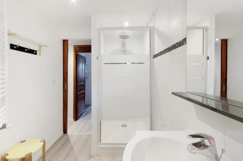 a white bathroom with a sink and a mirror at Lis Martagon in Font-Romeu