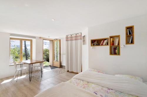 a bedroom with a bed and a table and a desk at Sorbier Des Oiseaux in Font-Romeu