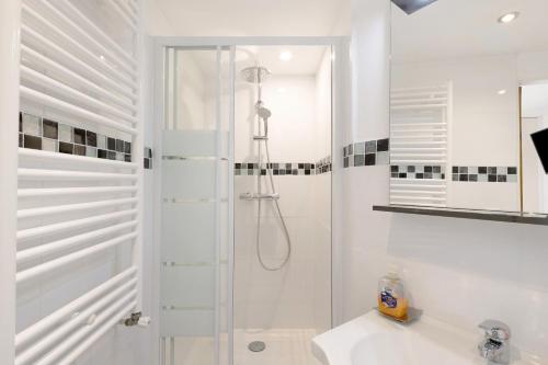 a white bathroom with a shower and a sink at Sorbier Des Oiseaux in Font-Romeu