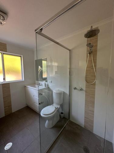 a bathroom with a toilet and a glass shower at Cozy Curtin Cottage in Lyons