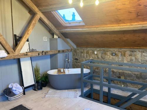 a bathroom with a bath tub in a attic at The Stable Sleeps 2 with Parking in Llanfairpwllgwyngyll