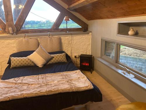 a bedroom with a bed in a room with windows at The Stable Sleeps 2 with Parking in Llanfairpwllgwyngyll