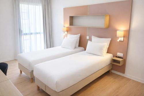 a hotel room with two beds and a window at Apparthotel Privilodges Toulon Centre Gare in Toulon
