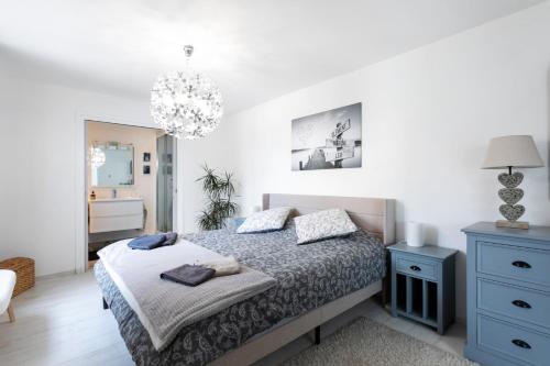 a bedroom with a bed and a chandelier at Macleo proche plage in Plougasnou