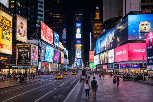 people walking on a busy city street at night at OYO Times Square in New York