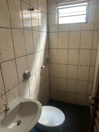 a bathroom with a white toilet and a sink at Cardoso Palace Hotel Ouro Verde in Rio Verde