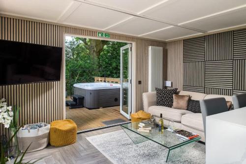 a living room with a couch and a tub at Badgers Sett in Hankerton