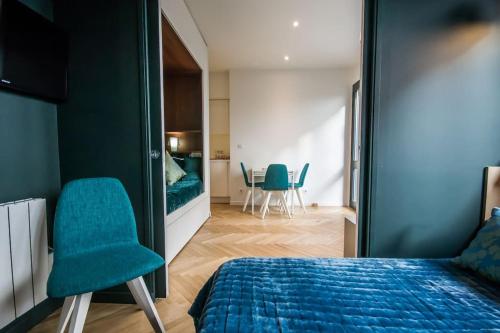 une chambre avec un lit et des chaises dans une pièce dans l'établissement Studio Royan, à Royan