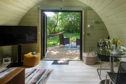 a living room with a door open to a patio at Squirrels Drey in Hankerton