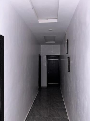 a hallway with a black door and a ceiling at Urban Nest Lodge in Ikeja