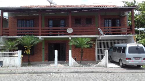 a van parked in front of a red brick building at Pousada Cama & Café in Navegantes