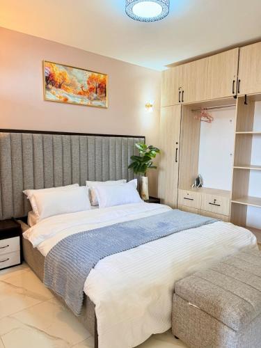 a bedroom with a large bed in a room at Plush stays UG in Buwate
