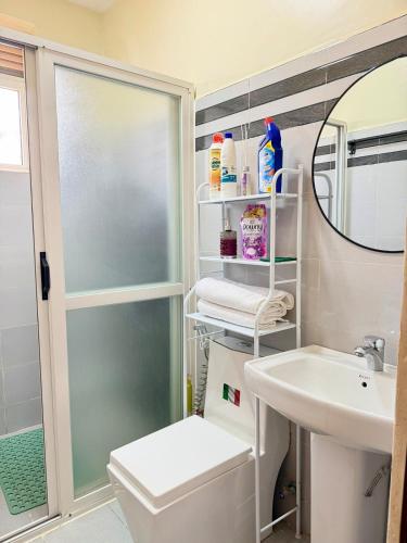a bathroom with a sink and a toilet and a mirror at Plush stays UG in Buwate