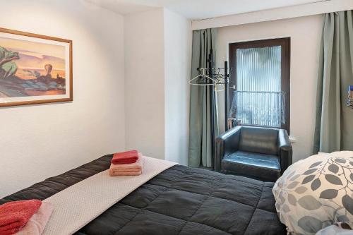 a bedroom with a bed and a chair in it at Rosenberg in Katzhütte