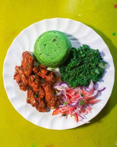 a white plate of food with broccoli and sauce at Jad Captains Hotel in Machakos