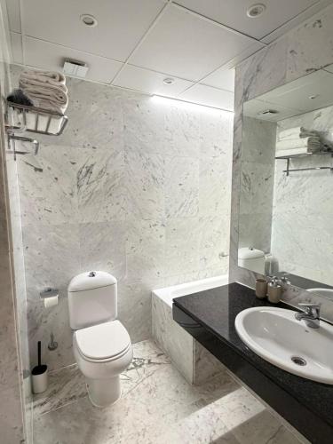 a white bathroom with a toilet and a sink at VTZ The Orus Factory Hotel - Parking Muy Económico in Zaragoza