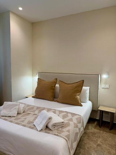 a bedroom with a large white bed with towels on it at VTZ The Orus Factory Hotel - Parking Muy Económico in Zaragoza
