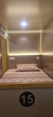 a bed in a small room with a sign on it at CaiPods Backpacker Hostel by G10 Guest House Bandung in Bandung