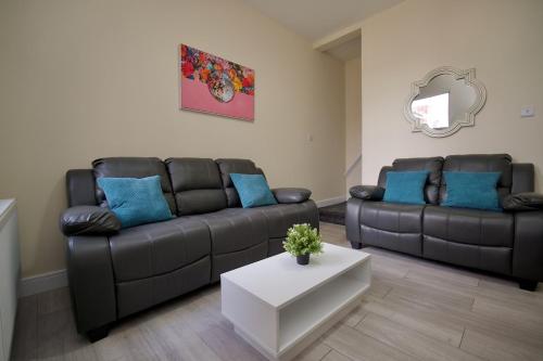 a living room with two couches and a table at Hamilton's Rest Serviced Accommodation - Coventry in Coventry