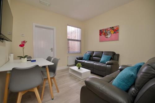 a living room with a couch and a table at Hamilton's Rest Serviced Accommodation - Coventry in Coventry
