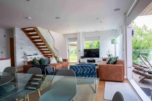 a living room with a glass table and a television at Malachite in South Cerney