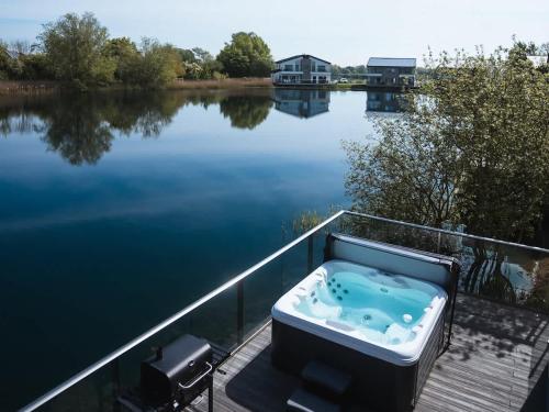 eine Badewanne auf einem Steg neben einem Gewässer in der Unterkunft Maricor in South Cerney