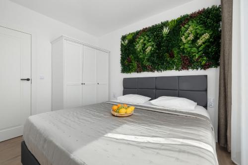 a bedroom with a bed with a bowl of fruit on it at Perfect Holiday Apartments Bel Mare by Noclegi Renters in Międzyzdroje