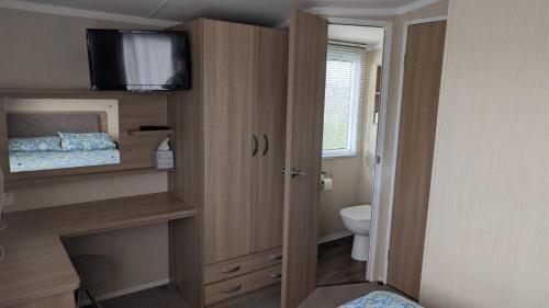 a bathroom with a toilet and a television in a room at The Speculation Inn - 3 Bedroom Static Caravan in Pembroke