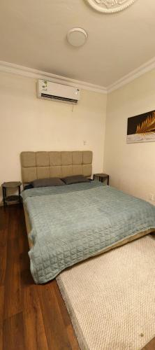a bedroom with a bed with a green comforter at شقق الفيصل in Al Khobar