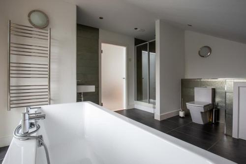 a white bathroom with a sink and a toilet at Goose Landing in South Cerney