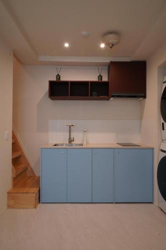 a kitchen with white cabinets and a sink at Covon Stay in Busan