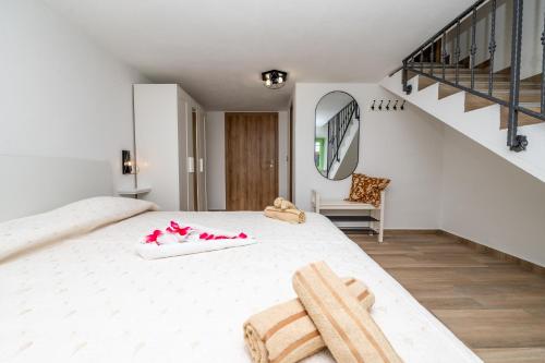 a bedroom with a large white bed and a staircase at Sant'Antonio in Orlec