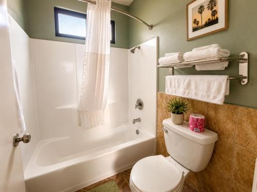 a bathroom with a toilet and a tub and a sink at Big A Motel & Suites Near Disneyland Orange County in Orange