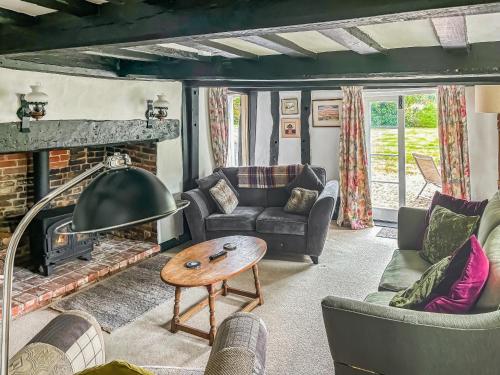 a living room with a couch and a fireplace at Willow Cottage in Framlingham