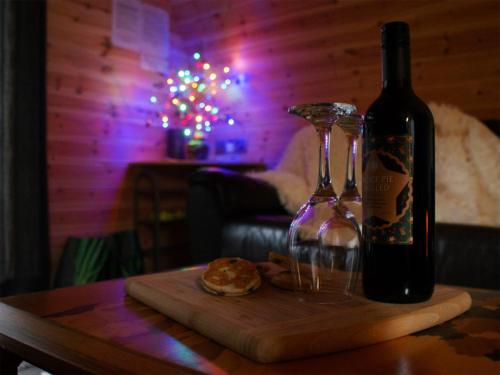 a bottle of wine and two glasses on a table at Creyr Glas Pod -Uk41796 in Hirnant