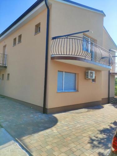 a house with a balcony on the side of it at Dragiv 1 in Selce