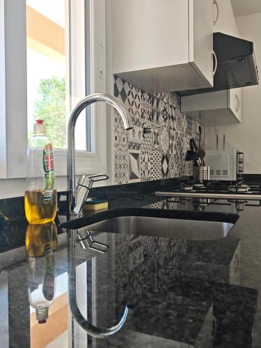 a kitchen counter with a sink and a bottle of wine at Marca 34 in Monção