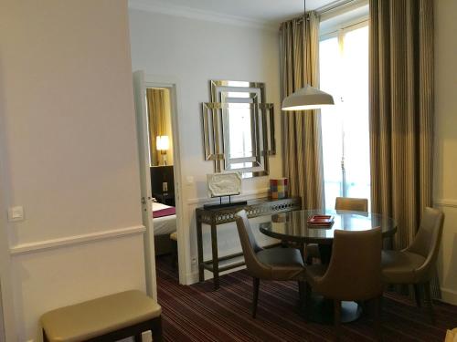 a living room with a table and a mirror at Elysées Union in Paris